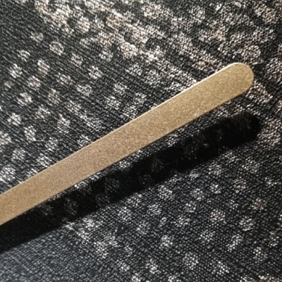 Primo particolare: Un orologio da parete nero con puntini e lancette dorati. Un design geometrico e raffinato che trasmette modernità e lusso. Un’aggiunta sofisticata e contemporanea all’arredamento.