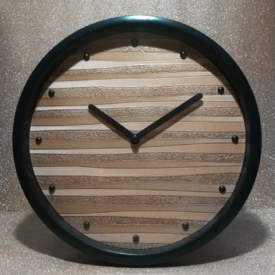 Orologio dal design dinamico con colori arancione, giallo e oro. Linee irregolari aggiungono vitalità. Cornice nera e lancette garantiscono eleganza contemporanea. Un'idea regalo per chi cerca stile e originalità nell'arredamento.