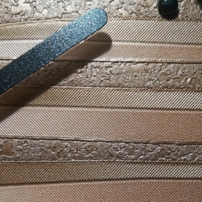 Primo particolare: Orologio dal design dinamico con colori arancione, giallo e oro. Linee irregolari aggiungono vitalità. Cornice nera e lancette garantiscono eleganza contemporanea. Un'idea regalo per chi cerca stile e originalità nell'arredamento.