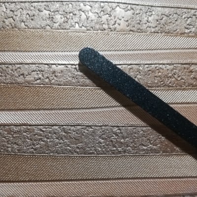 Secondo particolare: Orologio dal design dinamico con colori arancione, giallo e oro. Linee irregolari aggiungono vitalità. Cornice nera e lancette garantiscono eleganza contemporanea. Un'idea regalo per chi cerca stile e originalità nell'arredamento.