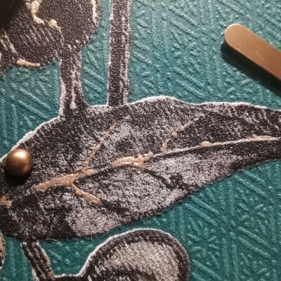 Secondo particolare: Esplora l'eleganza della natura con questo orologio da parete verde, impreziosito da una lavorazione a rombi e decorazioni floreali in nero, argento e oro. Lancette dorate su fondo verde, cornice nera: un equilibrio perfetto tra modernità e raffinatezza, trasformando l'orologio in un'opera d'arte unica.