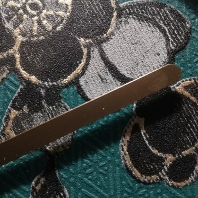 Primo particolare: Esplora l'eleganza della natura con questo orologio da parete verde, impreziosito da una lavorazione a rombi e decorazioni floreali in nero, argento e oro. Lancette dorate su fondo verde, cornice nera: un equilibrio perfetto tra modernità e raffinatezza, trasformando l'orologio in un'opera d'arte unica.
