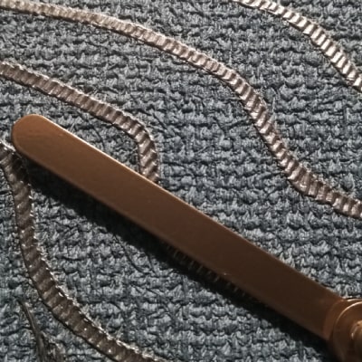 Primo particolare: L'orologio blu moderno con onde dorate dall'effetto tessuto unisce modernità e lusso. La base tessile blu, le onde dorate e le lancette nere creano un design sofisticato. Un regalo unico per aggiungere stile e dinamismo all'arredamento.